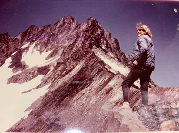 A photograph of a woman climbing a mountain