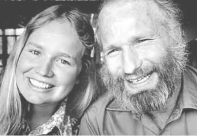 an older man and a younger woman, leaning their heads together and smiling for the camera