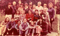 An old photograph of a group of people smiling and posing for a picture